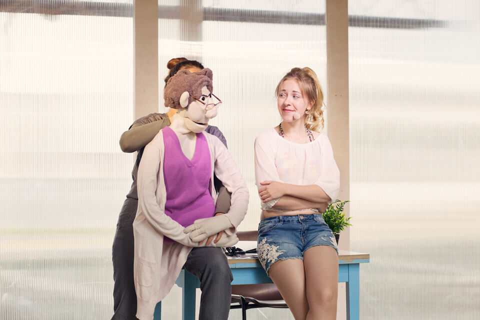 Theaterszene aus Hinter den Fenstern, Figur Ilona holt sich einen Rat von Puppenfigur Helga