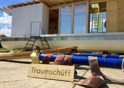 Bau des Traumschüffs Genossin Rosi, Bauhaus Weimar, Rohbau an Land, Blick auf das Traumschüff Schild