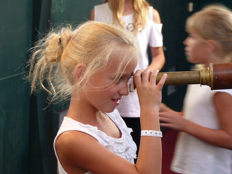 Theatervermittlungsprogramm Theater begegnen, Mädchen schaut durch ein Fernglas