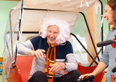 Senior mit Perücke auf, lachend in der Rikscha