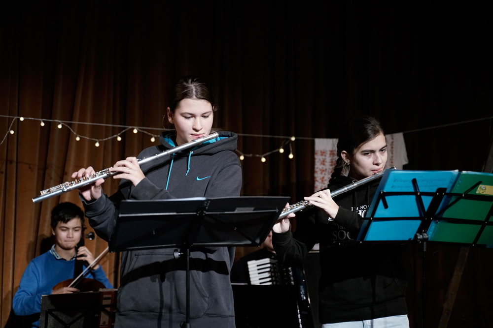 zwei Querflötistinnen im Vordergrund, junge mit Geige im Hintergrund